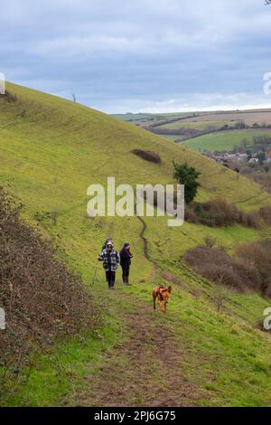 Ältere Wanderer mit Hund auf dem Hügel des Cerne Abbas Giant in Dorset, England Stockfoto