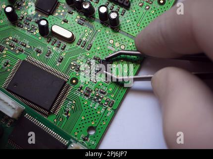 SMD-Chip von der elektronischen Leiterplatte demontiert. Hintergrund der Mikroelektronik- oder Halbleiterindustrie. Stockfoto