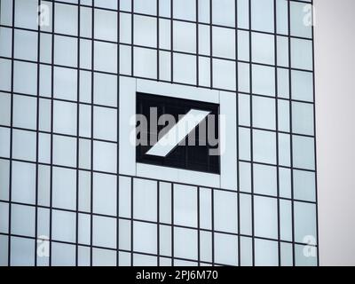 Deutsche Bank-Logo an der Fassade der Zwillingstürme. Reflektierendes Glaslogo als architektonisches Merkmal der Fassade. Deutsche Investmentbank. Stockfoto