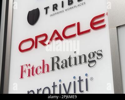 Logo von Oracle Corporation and Fitch Ratings am Eingang eines Bürokomplexes. Amerikanisches Computertechnikunternehmen und eine Rating-Agentur. Stockfoto