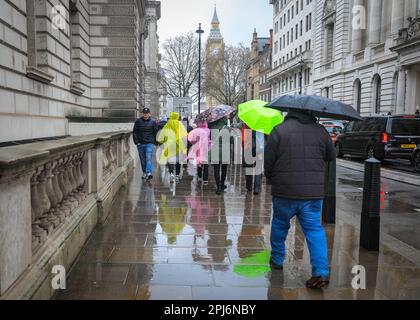 London, Großbritannien. 31. März 2023. Londoner und Touristen bekommen ihre Schirme raus, während sie einen Spaziergang durch die Westminster Sehenswürdigkeiten im Zentrum von London machen, an einem Tag, der meist grau und sehr regnerisch in der Hauptstadt war. Kredit: Imageplotter/Alamy Live News Stockfoto