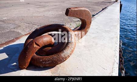 Ein alter, großer und rostiger Anlegehaken für Schiffe am Dock. Stockfoto