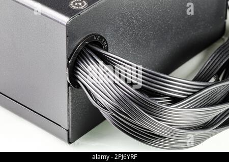 Flachbandkabel aus dem Stromversorgungskabel (PSU) des Computers zur Hauptplatine des Computers isoliert auf weißem Hintergrund. Stockfoto