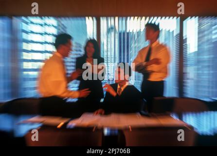 1996 HISTORISCHE ASIATISCHE BÜROANGESTELLTE TREFFEN SICH AM TISCH Stockfoto