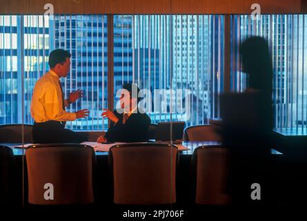 1996 HISTORISCHE ASIATISCHE BÜROANGESTELLTE TREFFEN SICH AM TISCH Stockfoto