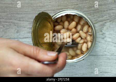 Blechdose mit weißen Bohnen auf dem Tisch Stockfoto