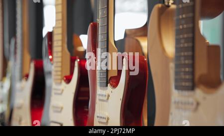 Elektrische Gitarren in einem Instrumentenladen, an einer Wand aufgehängt, Nahaufnahme. Stockfoto