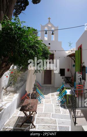 IOS, Griechenland - 26. Mai 2021 : Blick auf ein malerisches Restaurant neben einer kleinen orthodoxen Kirche in iOS Griechenland Stockfoto