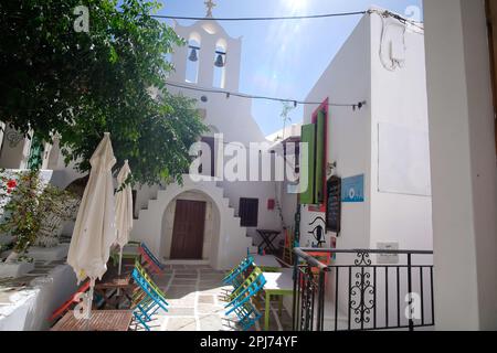 IOS, Griechenland - 26. Mai 2021 : Blick auf ein malerisches Restaurant neben einer kleinen orthodoxen Kirche in iOS Griechenland Stockfoto