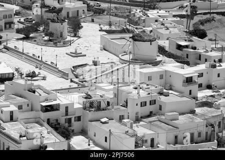 Blick auf die weiß getünchten Wohngebäude, alten Windmühlen und Häuser in iOS Greece von oben in Schwarz und Weiß Stockfoto