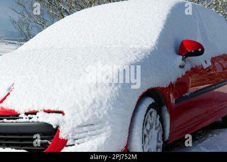 Das Auto ist mit frischer Schneeschicht bedeckt Stockfoto