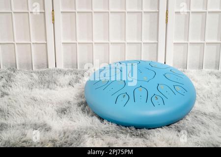 Blaue Zungentrommel aus Stahl auf einem flauschigen Teppich Stockfoto