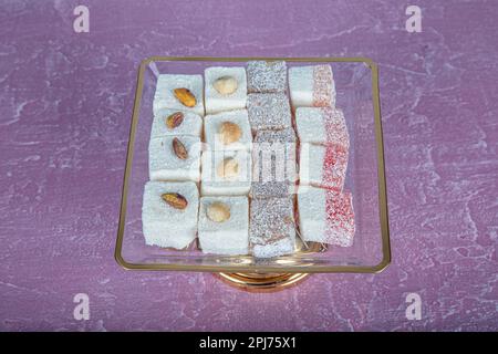 Türkischer Honig, türkischer Honig, auf einer Kristallglasplatte. Rosafarbener Holzhintergrund. Stillleben, Essen und Trinken, saisonal und Urlaub (ramadan, Zucker Stockfoto