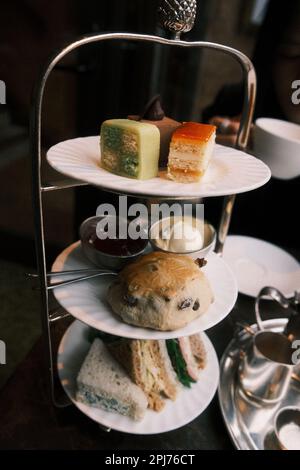 Ein Nachmittagstee mit einer Auswahl köstlicher Sandwiches und süßer Köstlichkeiten Stockfoto