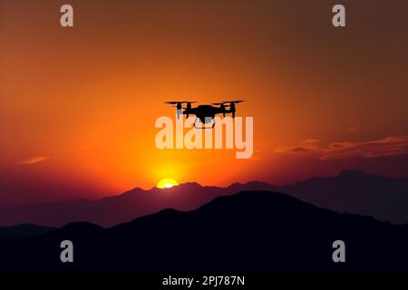 Die Silhouette der fliegenden Drohne im goldenen Himmel des Sonnenuntergangs Stockfoto
