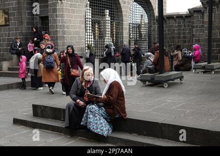 30. März 2023, Diyarbakir, Türkei: Eine Frau wird gesehen, wie sie einer anderen Frau beim Besuch der Schreine in Diyarbakir zuhört, die den Koran rezitiert. Im Monat Ramadan besuchen Sie heilige Stätten und Schreine, beten und wünschen sich etwas. Einer dieser heiligen Stätten ist die Hazrat Suleyman Moschee, die 1150 erbaut wurde und eines der wichtigsten religiösen und touristischen Zentren der Moslems der Welt ist. Im Garten der Moschee gibt es Schreine von 27 Menschen, die hier während der Ausbreitung des Islam starben und angeblich Nachkommen des Propheten (Sahaba) Mohammed waren. Wer die Schreine besucht, liest den Koran Stockfoto