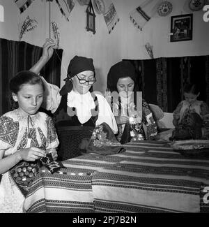 Sibiu County, Rumänien, ca. 1977. Eine Gruppe von Frauen verschiedener Generationen, die traditionelle folkloristische Kleidung von Hand nähen. Stockfoto