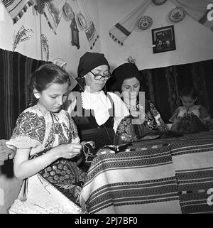 Sibiu County, Rumänien, ca. 1977. Eine Gruppe von Frauen verschiedener Generationen, die traditionelle folkloristische Kleidung von Hand nähen. Stockfoto