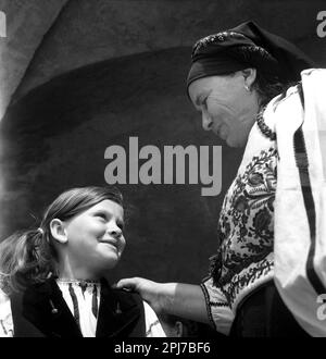 Sibiu County, Rumänien, ca. 1977. Einheimische Frau und Enkelin, die traditionelle handgefertigte folkloristische Kleidung tragen. Stockfoto