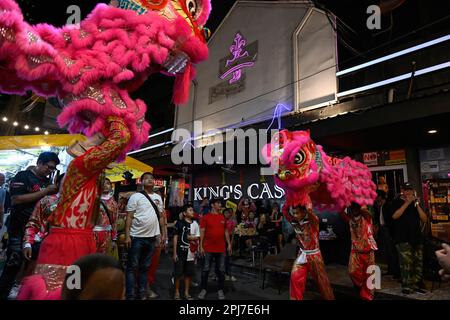 Bangkok, Thailand. 30. März 2023. Chinesische Löwentänzer treten auf der Straße vor. Bangkoks berüchtigtes Rotlicht-Unterhaltungsviertel Patpong wurde seit der COVID-19-Pandemie wieder eröffnet. Es ist wieder ein Street Food Nachtmarkt mit nur wenigen Go Go Go Bars, 2 Straßen bieten auch Souvenirs, Kleidung und Schmuck. Seit der Legalisierung von Marihuana am 9. Juni wurden auch Marihuana-Verkaufsstellen in der Region eröffnet. (Foto: Paul Lakatos/SOPA Images/Sipa USA) Guthaben: SIPA USA/Alamy Live News Stockfoto