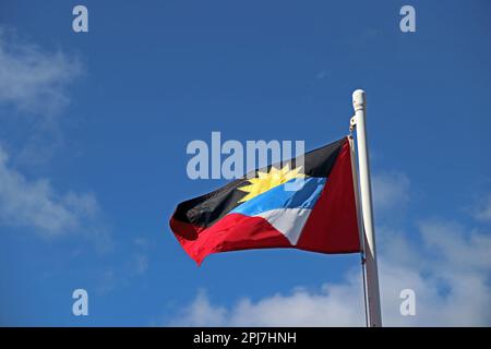 Die Nationalflagge von Antigua und Barbua, die vom Fahnenmast, Nelson's Harbour, Antigua aus fliegen Stockfoto