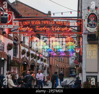 In Belfast trinken Leute, die an einem nassen Frühlingstag vor dem Herzog von York in Belfast sitzen und sich unterhalten. Stockfoto