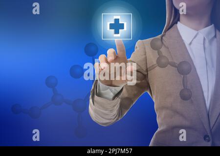 Frau drückt virtuellen erste-Hilfe-Knopf auf blauem Hintergrund, Nahaufnahme. Notfallhilfe Stockfoto