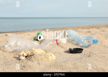 Müll verstreut am Strand in der Nähe des Meeres, dicht gemacht. Recycling-Problem Stockfoto