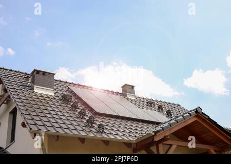 Haus mit installierten Sonnenkollektoren auf dem Dach. Alternative Energie Stockfoto