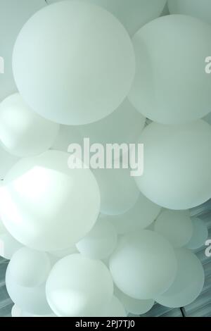 Weiße Ballons, weiße aufblasbare Bälle, Plastikkugel, Hintergrund mit weißen und grauen Kreisen, festlicher Hintergrund mit Ballons in Schwarzweiß. Hochwertiges Foto Stockfoto