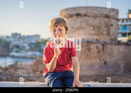 Junge Touristen, die türkisches Eis im Hintergrund des Hidirlik-Turms in Antalya vor dem Hintergrund der mediterranen Bucht der alten Kaleici essen Stockfoto