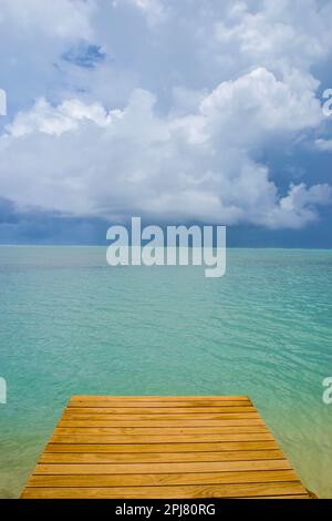 Eine Anlegestelle in der Lagune der Insel Aitutaki mit Blick auf den nahenden dunklen Himmel, Cook Islands, Pazifik. Stockfoto