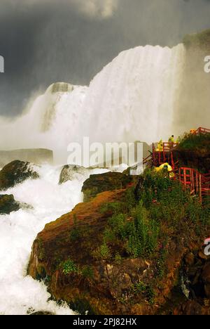 Ein hölzerner Fußweg führt Besucher zum Fuß der amerikanischen Wasserfälle in der „Cave of the Winds“-Attraktion Niagara Falls Stockfoto