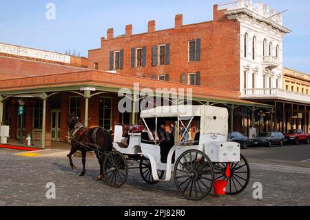 Ein Pferd und ein Karraige führt Besucher auf eine Tour durch die historische Altstadt von Sacramento, Kalifornien Stockfoto