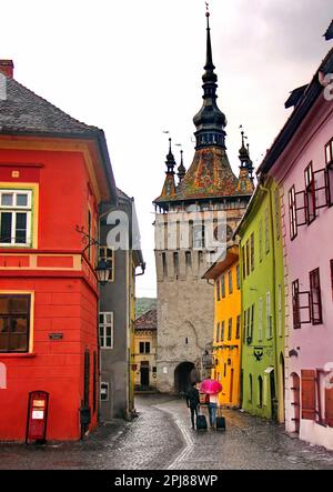 Reisende in Sighisoara - Altstadt der mittelalterlichen Stadt von Siebenbürgen, Rumänien. Im Regen laufen Stockfoto