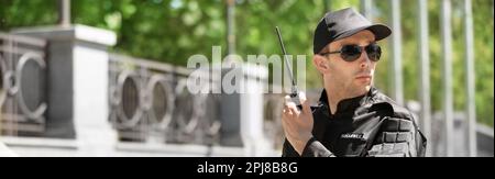 Männlicher Wachmann mit tragbarem Funksender im Freien. Bannerdesign Stockfoto