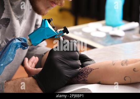 Professioneller Künstler, der im Salon tätowiert, Nahaufnahme Stockfoto