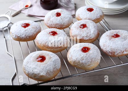 Viele köstliche Donuts mit Gelee und Puderzucker auf dem Kühlregal Stockfoto