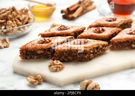 Köstliches Honigbaklava mit Walnüssen auf einem weißen Marmortisch, Nahaufnahme Stockfoto