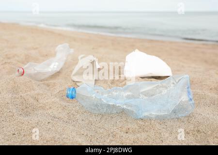 Müll verstreut am Strand in der Nähe des Meeres, dicht gemacht. Recycling-Problem Stockfoto
