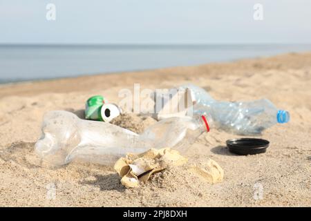 Müll verstreut am Strand in der Nähe des Meeres, dicht gemacht. Recycling-Problem Stockfoto