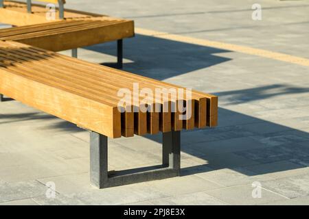 Holzbank in der Stadt am sonnigen Morgen Stockfoto