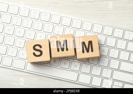 Abkürzung SMM mit Holzwürfeln auf Computertastatur, Draufsicht. Social-Media-Marketing Stockfoto