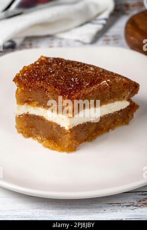 Brotpudding auf Holzboden. Traditionelles Ramadan-Dessert. Brot Kadayif mit Sahne in der Mitte. Lokaler Name Kaymaklı ekmek kadayifi. Schließen Stockfoto