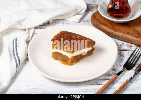 Brotpudding auf Holzboden. Traditionelles Ramadan-Dessert. Brot Kadayif mit Sahne in der Mitte. Lokaler Name Kaymaklı ekmek kadayifi Stockfoto