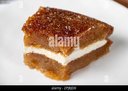 Brotpudding auf Holzboden. Traditionelles Ramadan-Dessert. Brot Kadayif mit Sahne in der Mitte. Lokaler Name Kaymaklı ekmek kadayifi. Schließen Stockfoto