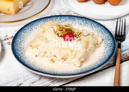 Güllac, Revani, Tulumba und Brot Kadayif Dessert mit Sahne auf einem Holzboden. Ramadan-Süßigkeiten. Traditionelle türkische Köstlichkeiten Stockfoto