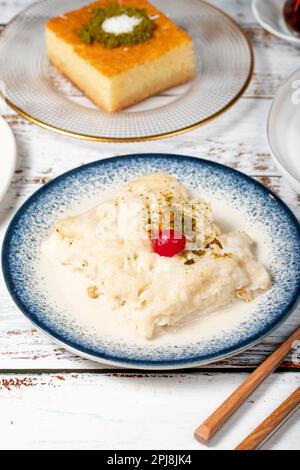 Güllac, Revani, Tulumba und Brot Kadayif Dessert mit Sahne auf einem Holzboden. Ramadan-Süßigkeiten. Traditionelle türkische Köstlichkeiten Stockfoto