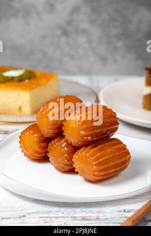 Güllac, Revani, Tulumba und Brot Kadayif Dessert mit Sahne auf einem Holzboden. Ramadan-Süßigkeiten. Traditionelle türkische Köstlichkeiten. Schließen Stockfoto