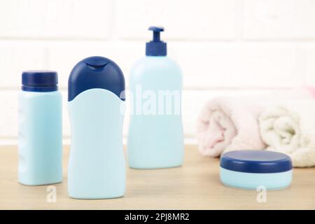 Blaue Kosmetikflaschen mit Handtüchern auf weißem Hintergrund. Fläschensatz Stockfoto